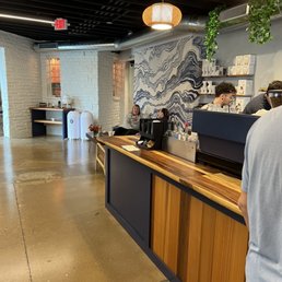 a man standing at a counter in a coffee shop