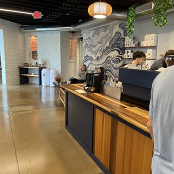 North Street - a man standing at a counter in a coffee shop - Bakeries Near Me - Madison, Wisconsin