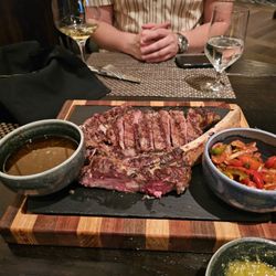 Bistro Mariposa - Tomahawk Ribeye served with with chimichurri, macha, a red wine chipotle bone marrow reduction, and smashed fingerling potatoes