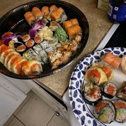 two plates of sushi on a counter two plates of sushi on a counter