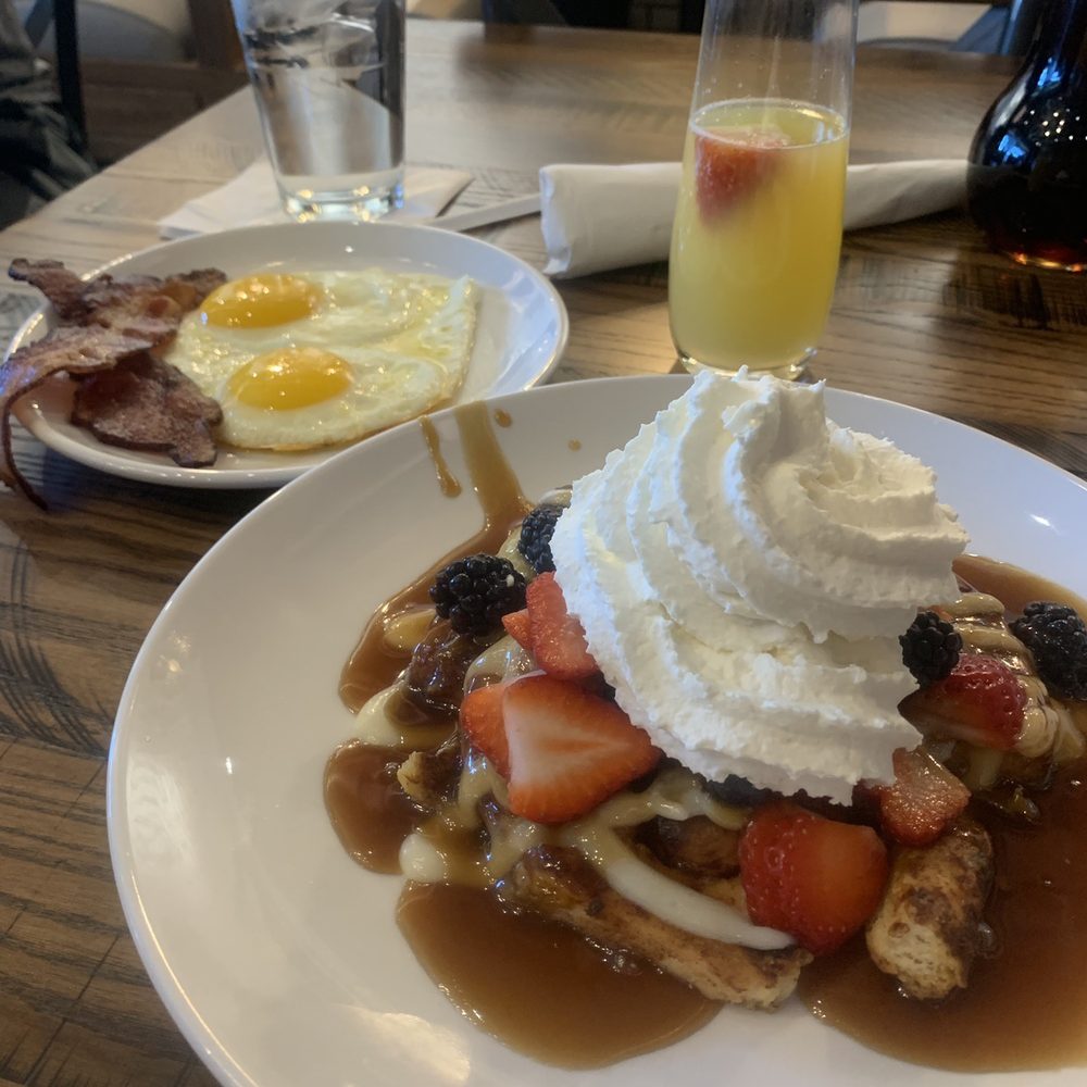 Another Broken Egg Cafe - French Toast Cinnamon roll covered in berries, cream cheese, syrup, and whip cream. With a side of bacon, sunny side up eggs, and a mimosa. - Breakfast & Brunch Near Me - Flowood, Mississippi Another Broken Egg Cafe - French Toast Cinnamon roll covered in berries, cream cheese, syrup, and whip cream. With a side of bacon, sunny side up eggs, and a mimosa. - Breakfast & Brunch Near Me - Flowood, Mississippi