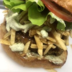 Vegan Junkie Burgers - Guava Shh..cken - guava glazed patty, lettuce, tomato, potato sticks, cilantro-garlic sauce served on a Sesame Vegan Brioche bun.
