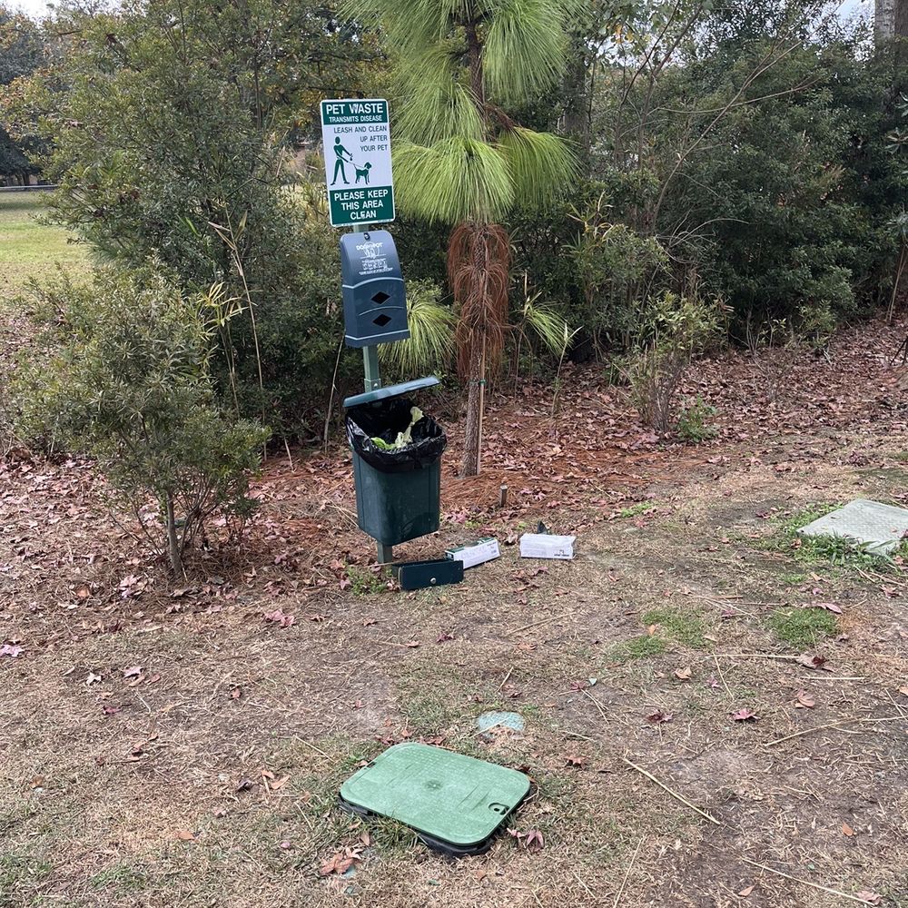 Dog waste bin that's been broken and trash thrown around it Dog waste bin that's been broken and trash thrown around it