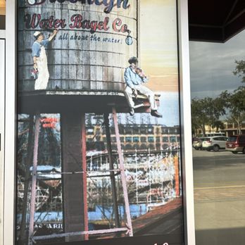 Brooklyn Water Bagel - a man on a ladder in front of a water tower - Bagels Near Me - Lady Lake, Florida