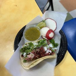Carnitas taco, beautiful detail on plate with sauce and radish Carnitas taco, beautiful detail on plate with sauce and radish