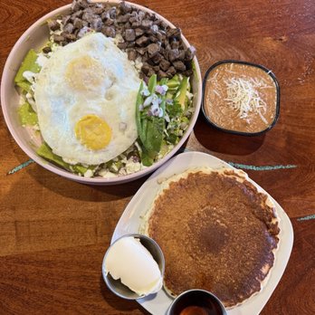 Amelias Mexican Kitchen - Chilaquiles with green sauce and carne asada with two over medium eggs. Refried beans. One single pancake. - Mexican Near Me - Tucson, Arizona Amelias Mexican Kitchen - Chilaquiles with green sauce and carne asada with two over medium eggs. Refried beans. One single pancake. - Mexican Near Me - Tucson, Arizona