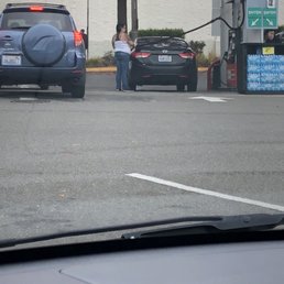 a woman filling up her car at a gas station a woman filling up her car at a gas station