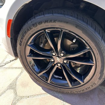 CDI Mobile Detailing  - A car wheel featuring a black alloy rim and a General G-MAX tire is shown, with part of the vehicle's body and a concrete surface in the background. - Auto Detailing Near Me