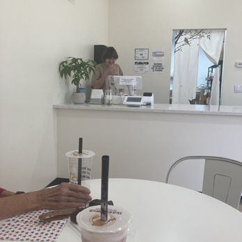 Bubble Well - a woman sitting at a table with a drink - Bubble Tea Near Me - Fort Worth, Texas Bubble Well - a woman sitting at a table with a drink - Bubble Tea Near Me - Fort Worth, Texas
