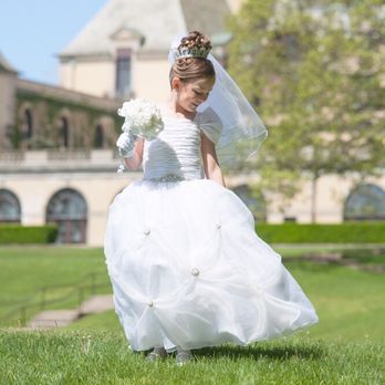 Storm Photographers - Communion girl admiring  her gorgeous gown in the field at Oheka Castle. - Event Photography Near Me