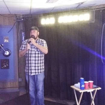 Gayle's - a man standing in front of a microphone - Bars Near Me - Topeka, Kansas