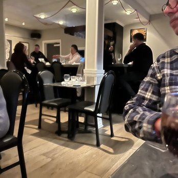 Freelance Cafe & Wine Bar - a man sitting at a table with a glass of wine - New American Near Me - Piermont, New York Freelance Cafe & Wine Bar - a man sitting at a table with a glass of wine - New American Near Me - Piermont, New York
