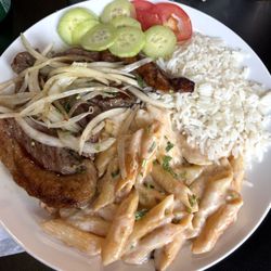Q'Delicia Brazilian House - Steak and onions, side pasta with white sauce, rice, and cucumbers with tomato.