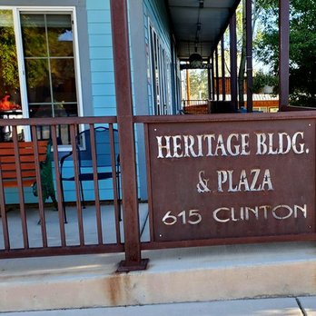 Kate's Place - A metal sign attached to a railing shows the name 'Heritage Bldg. & Plaza' and the address '615 Clinton' in white lettering. - American Near Me - Ridgway, Colorado