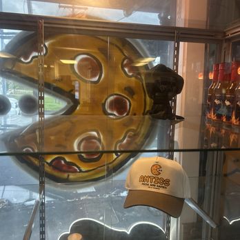 Antics Pizza - Painting of a pizza on window, and a hat sold at this tea. - Pizza Near Me - Hilo, Hawaii