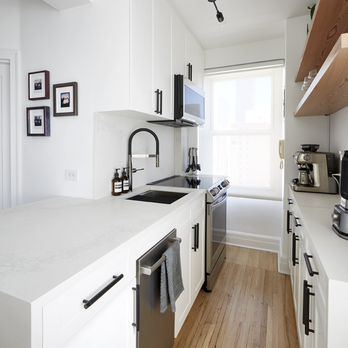 Maverick Design & Build - Gallery Style Kitchen, Beige white kitchen cabinet with oak finish hardwood floor and stainless steel appliances. Astoria, New York - General Contractors Near Me - New York, New York Maverick Design & Build - Gallery Style Kitchen, Beige white kitchen cabinet with oak finish hardwood floor and stainless steel appliances. Astoria, New York - General Contractors Near Me - New York, New York