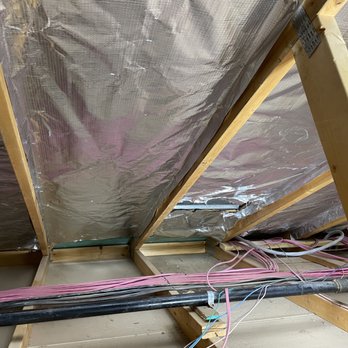 LV Attic Pros - Vacuumed attic cleaned floor showing the lowest point, Installed silver radiant barrier to the bottom of roof pitch meeting attic floor. - Insulation Installation Near Me