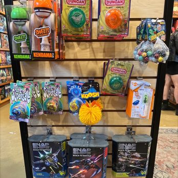 Cloud Cap Games - Store rack holding toys such as Kendama, Yo-Yo, and building kits, with packaging and some loose items, in a retail environment. - Tabletop Games Near Me - Portland, Oregon