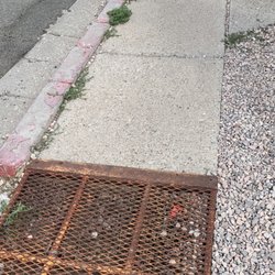Gallup Indian Medical Center - Walkway full of gravel, obstacles, and rusted grates - outdated at best