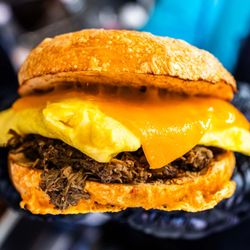 David Doughie's Bagelry - Zhug Life; Chipotle cheddar bagel, with 2 farm fresh eggs, cheddar cheese, braised barbacoa and zhug salsa verde.