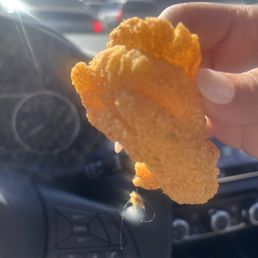 a hand holding a piece of fried food a hand holding a piece of fried food