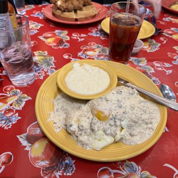 The Flying Biscuit Cafe - Biscuits and gravy topped with eggs and a side of grits - Breakfast & Brunch Near Me - Cary, North Carolina