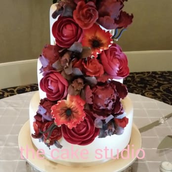 The Cake Studio - a wedding cake with red flowers - Desserts Near Me The Cake Studio - a wedding cake with red flowers - Desserts Near Me