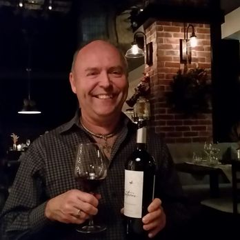 Maison Boire - a man holding a bottle of wine - Canadian (New) Near Me - Granby, Quebec