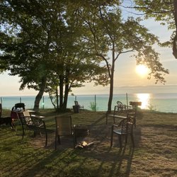 Curley's Paradise Motel - Bay sunrise view of fire ring and picnic table with grill