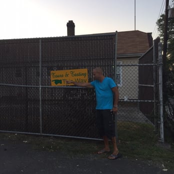 Climax Brewing Co - a man standing in front of a fence holding a sign - Breweries Near Me - Roselle Park, New Jersey