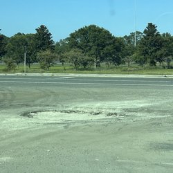 Tesla Supercharger - Large pothole at entrance to the Tesla lot.