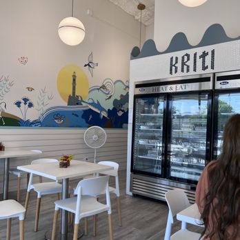 Kriti Kitchen - a woman sitting at a table - Greek Near Me - Houston, Texas Kriti Kitchen - a woman sitting at a table - Greek Near Me - Houston, Texas
