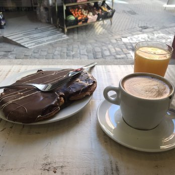 Pan y Più - Palmier covered in chocolate over a hazelnut filling, latte and a freshly squeezed orange juice. - Bakeries Near Me - Seville, SE Pan y Più - Palmier covered in chocolate over a hazelnut filling, latte and a freshly squeezed orange juice. - Bakeries Near Me - Seville, SE