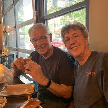 Sid's Garage - See how huge my Chicken Sandwich is and my husband is already digging into his. - Beer Bar Near Me - Boise, Idaho