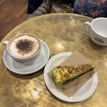 Caffè Nero - Cappuccino coffee and chocolate pistachio cake - Coffee & Tea Near Me - London, XGL Caffè Nero - Cappuccino coffee and chocolate pistachio cake - Coffee & Tea Near Me - London, XGL