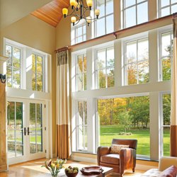 TW Perry - A bright and airy living room with soaring ceilings and large, floor-to-ceiling windows that let in natural light and showcas...