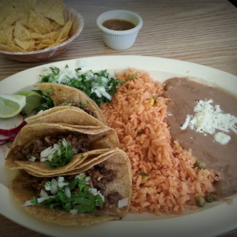 Three fajita tacos, rice, and beans.
