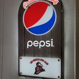 a pepsi sign hanging on a wall