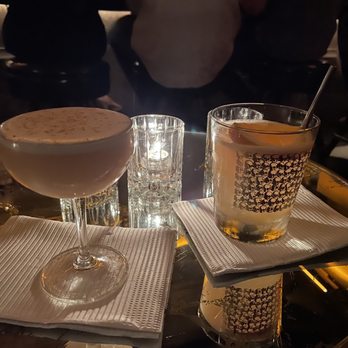 Noble Experiment - Their take on a Harvest Moon (left) and Golden Welsh (right). Love the glasses that match the skull wall. - Cocktail Bars Near Me - San Diego, California