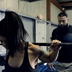 West Texas Strength Nutrition & Training Center - Owner and Coach Juan Martinez watching carefully as a member prepares for a set of squats.