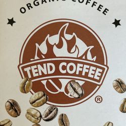 A picture of their pamphlet. Tend coffee logo stating organic coffee! Beans flying around it.