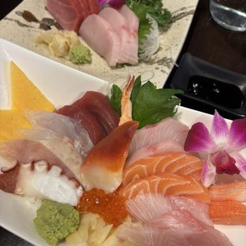 Kusshi - Assorted bowl and nigiri - A sashimi platter featuring slices of raw fish, shrimp, and octopus, garnished with wasabi, ginger, and edible flowers, served on a white dish. - Sushi Bars Near Me - Silver Spring, Maryland