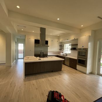 Ricardo Parra Construction Group - Modern two-tone kitchen with white cabinetry, dark wood island, quartz countertops, built-in appliances, and clean contemporary lines. - Cabinetry Near Me - Delray Beach, Florida Ricardo Parra Construction Group - Modern two-tone kitchen with white cabinetry, dark wood island, quartz countertops, built-in appliances, and clean contemporary lines. - Cabinetry Near Me - Delray Beach, Florida