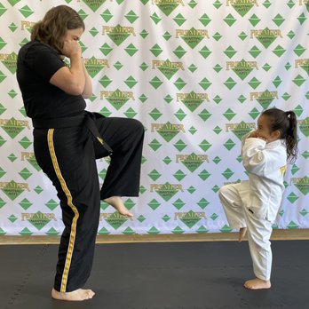 Premier Martial Arts - Teaching her how to properly chamber and kick during a free introductory lesson. - Martial Arts Near Me - Encinitas, California Premier Martial Arts - Teaching her how to properly chamber and kick during a free introductory lesson. - Martial Arts Near Me - Encinitas, California