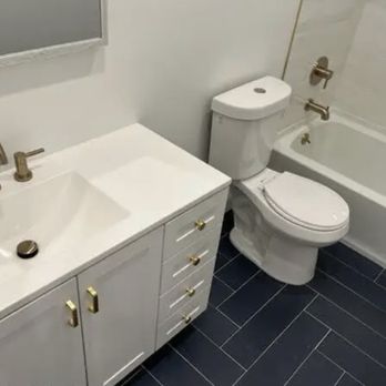 Ek Home Improvement - a bathroom with a toilet, sink, and bathtub - General Contractors Near Me Ek Home Improvement - a bathroom with a toilet, sink, and bathtub - General Contractors Near Me