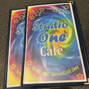 Studio One Cafe - Menu - Two menus for Studio One Cafe feature a vibrant swirl background with star decorations and the text 'Breakfast Served All Day.' - Breakfast & Brunch Near Me - Eugene, Oregon