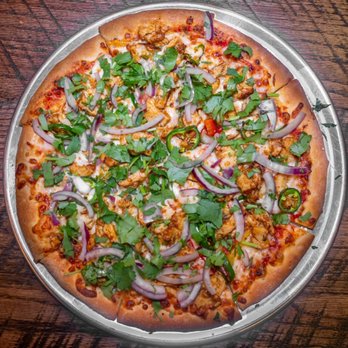 Pizza Vibes - a pizza on a pan on a wooden table - Pizza Near Me - The Colony, Texas Pizza Vibes - a pizza on a pan on a wooden table - Pizza Near Me - The Colony, Texas