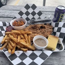 Chicken fried steak with fries, yams and a piece of cornbread.