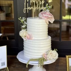 Violet Cake - Wedding cake with Mr. and Mrs. gold topper and mixed florals all around