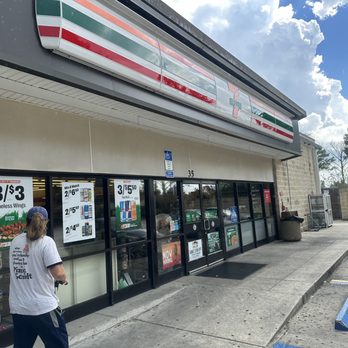7-Eleven - a man walking in front of a store - Gas Stations Near Me - Orlando, Florida